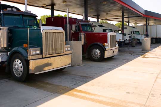 A row of trucks parked at the gas station.